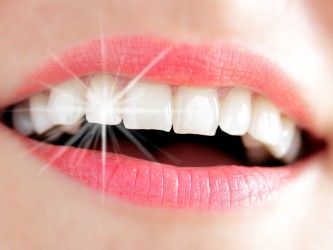 Frauenlachen mit Lichtreflex auf Zahn